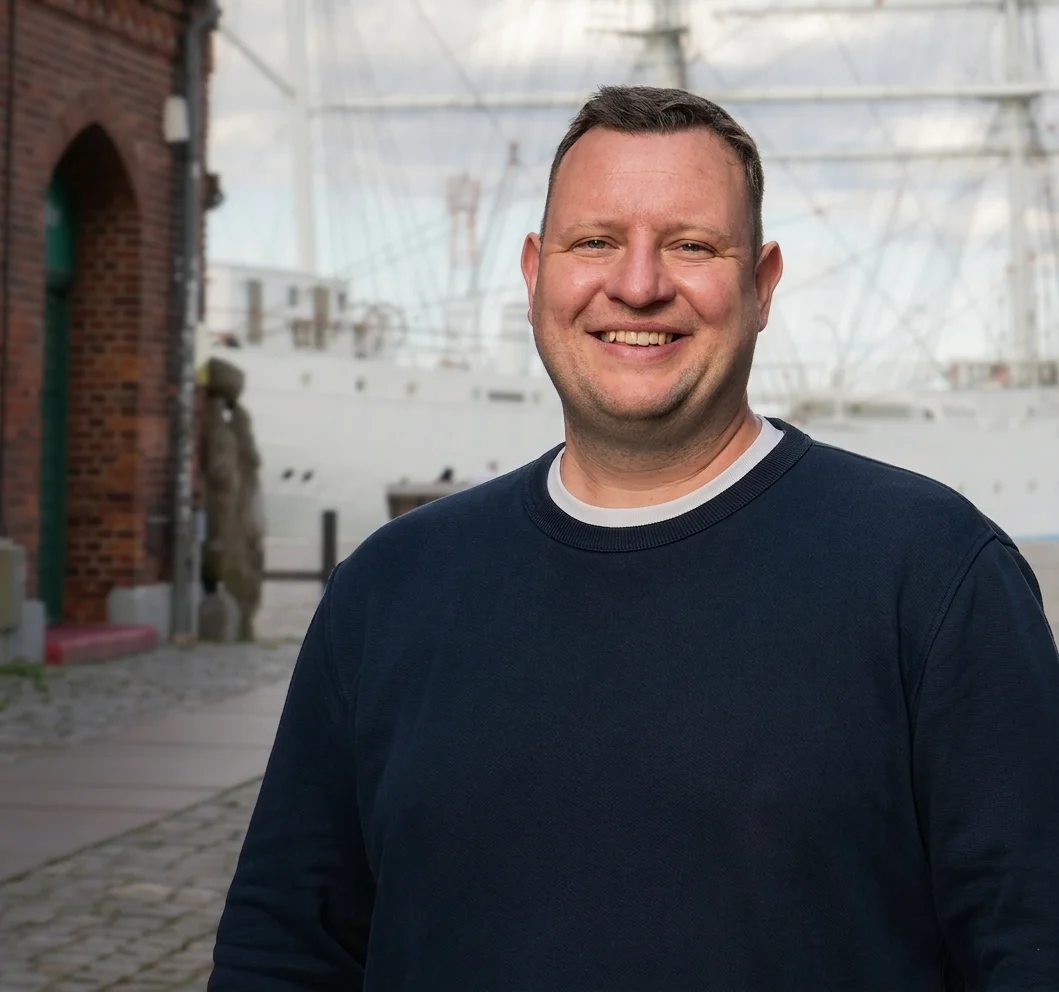 Porträt von Mathias, Recruiting-Berater bei Talentküste, in einer historischen Gasse in Stralsund.
